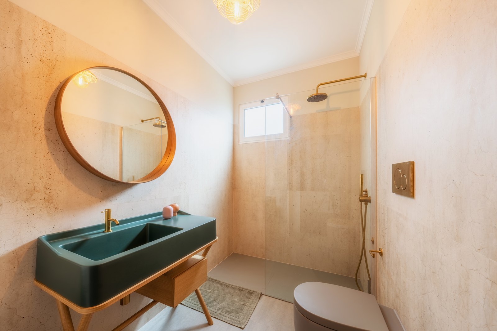 Santa Catarina Apartment — Bathroom with a deep green basin on a timber stand, a round brass-framed mirror and a walk-in shower