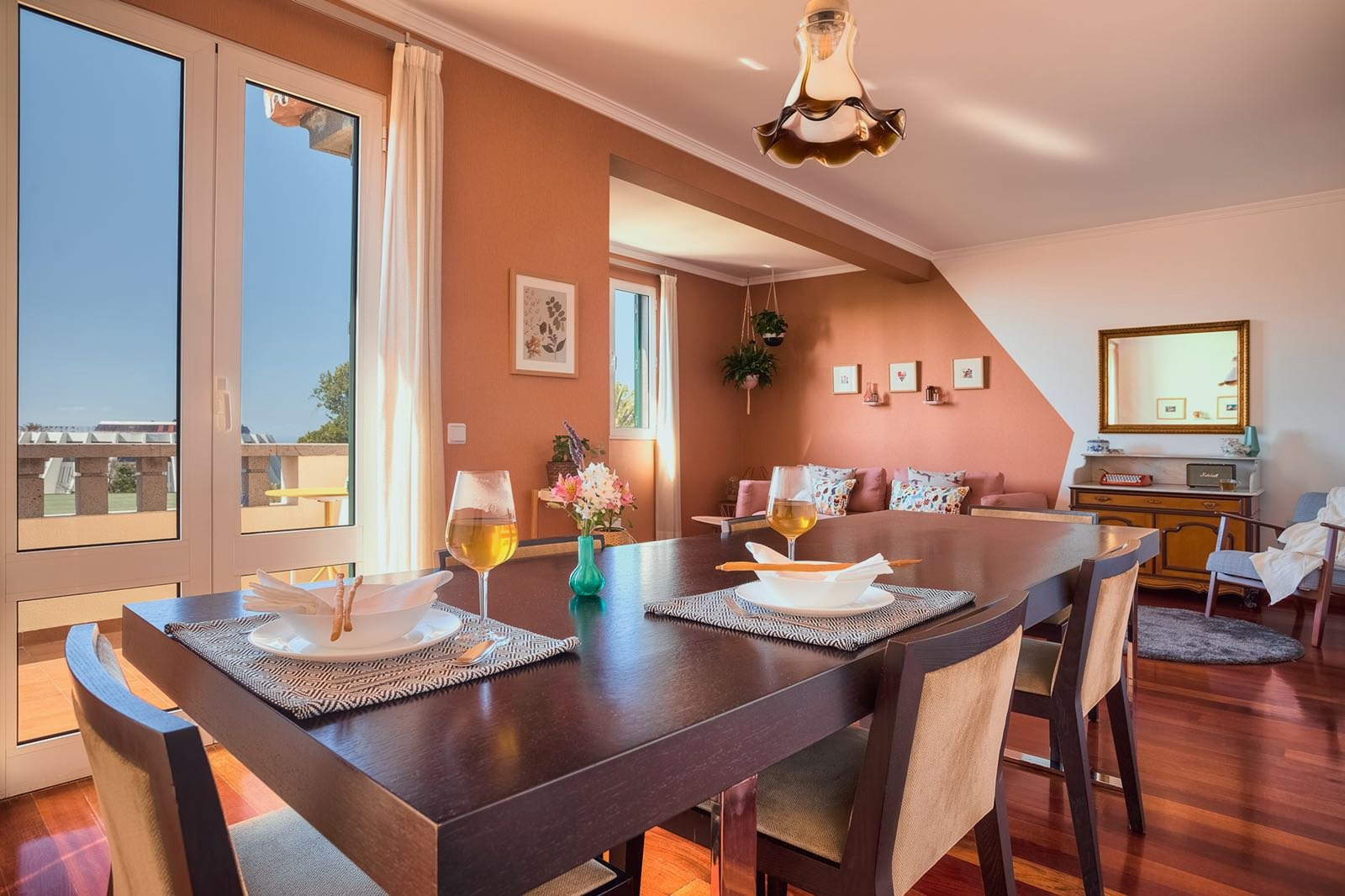 Santa Catarina Apartment — Dining table set by a glass door, with the sea visible beyond the balcony
